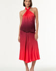Woman wearing a red halter neck dress with a gradient effect on a white background