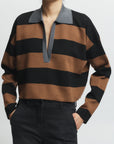 Person wearing a brown and black striped sweater with a gray collar on a white background