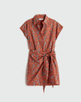 Orange patterned dress with a belt on a light gray background