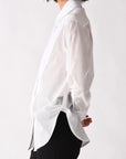 Person wearing a white shirt and black pants on a white background