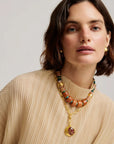 Woman wearing a beaded necklace with a neutral background