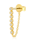 A gold huggie hoop earring featuring a vertical drop chain adorned with seven bezel-set clear round gemstones, shown on a plain white background.