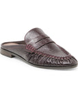 A dark brown textured leather mule loafer with a pebbled finish, featuring a stitched strap across the vamp and gathered detailing around the toe, shown against a plain white background.
