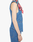 Woman wearing a blue denim outfit with a colorful scarf on a white background, side