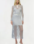 Woman wearing a sheer netted dress with a white collar on a white background