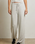 Person wearing light gray sweatpants with a plain background front view