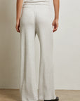 Person wearing light gray wide-leg pants against a neutral background back view