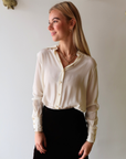 Woman wearing Alyssa Long Sleeve Bodysuit in Ivory and Felicity Velvet Midi Skirt against a plain background, front