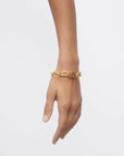 Gold chain bracelet on a person's wrist against a white background