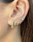 Single Copperhead Diamond Snake Huggie Hoop in model's ear paired with other earrings