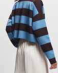 Person wearing a striped sweater with blue and brown horizontal stripes on a plain background, back