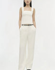 model wearing a white tank with white pants on a white background