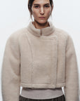 Woman wearing a beige fleece jacket on a white background