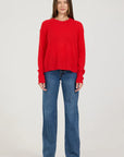 Person wearing a red sweater and blue jeans on a white background