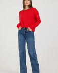 Person wearing a red sweater and blue jeans on a white background