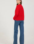 Person wearing a red sweater and blue jeans on a white background