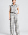 model wearing a grey and white plaid pant with a matching cowl neck sleeveless top