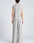 model wearing a grey and white plaid pant with a matching cowl neck sleeveless top, back view