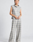 model wearing a grey and white plaid pant with a matching cowl neck sleeveless top