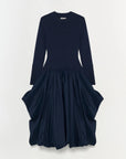 Navy blue dress with long sleeves and layered skirt on a white background