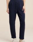 navy sweat pant on a model with sneakers and a white tee with a cream background