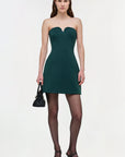 Woman wearing a strapless green dress on a white background