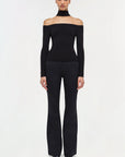 black longsleeve off shoulder lila top on a model with black jeans and a white background front