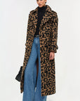 Woman wearing a leopard print coat with blue jeans on a white background