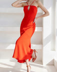 Woman wearing a red dress in a bright, minimalistic setting