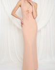 Woman wearing a long, light pink dress against a white background