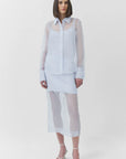 Woman wearing a light blue sheer outfit on a white background