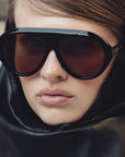 model wearing Sunglasses with brown lenses and black frame