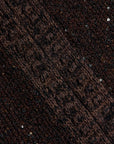 Close-up of a dark brown knit fabric with textured stripes and scattered small reflective sequins.