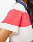 Woman wearing a colorful striped polo shirt on a white background