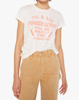Person wearing a white t-shirt with red text and beige pants on a white background