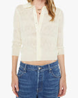 Woman wearing a cream-colored cropped shirt and blue jeans on a white background