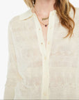 Woman wearing a light-colored shirt and sunglasses on a white background