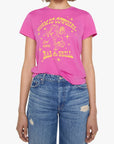 A woman modeling a bright pink graphic t-shirt with a yellow retro cowboy illustration and text reading 'Cosmic Cowgirl Bar & Grill'. She is wearing blue jeans and sunglasses against a plain white background.