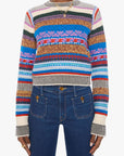A model wearing a colorful striped knit sweater with horizontal bands of blue, red, orange, yellow, green, and cream, paired with dark blue jeans against a plain white background.