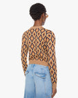 Person wearing a patterned sweater and jeans on a white background