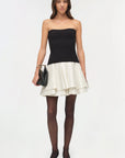 Isabelle Taffeta Knit Mini Dress on a model holding a black bag with a white background, front