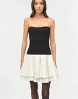Isabelle Taffeta Knit Mini Dress on a model holding a black bag with a white background
