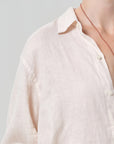 Close-up of a cream shirt on a gray background
