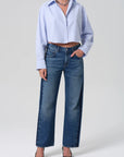 Person wearing a light blue shirt and blue jeans on a white background