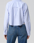 Light blue button-up shirt and blue jeans on a plain background