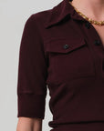 Close-up of a maroon ribbed sweater with a plain background detail view