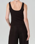 Person wearing a brown tank top and pants on a plain background