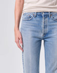 Light blue jeans worn by a person on a plain background