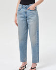 Person wearing light blue jeans on a white background