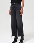 Person wearing black jeans and black boots on a white background